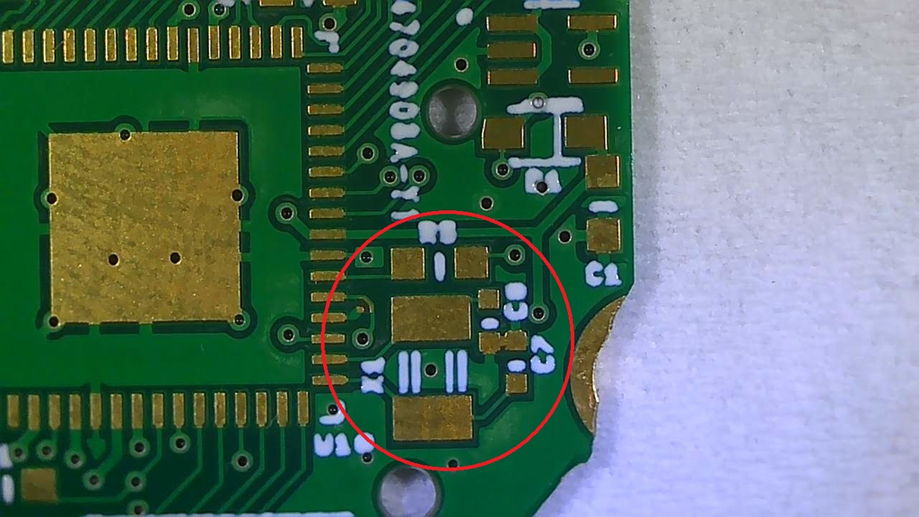 a closeup of a green sensor watch PCB, with an area circled. the area contains some small, and closely grouped copper pads