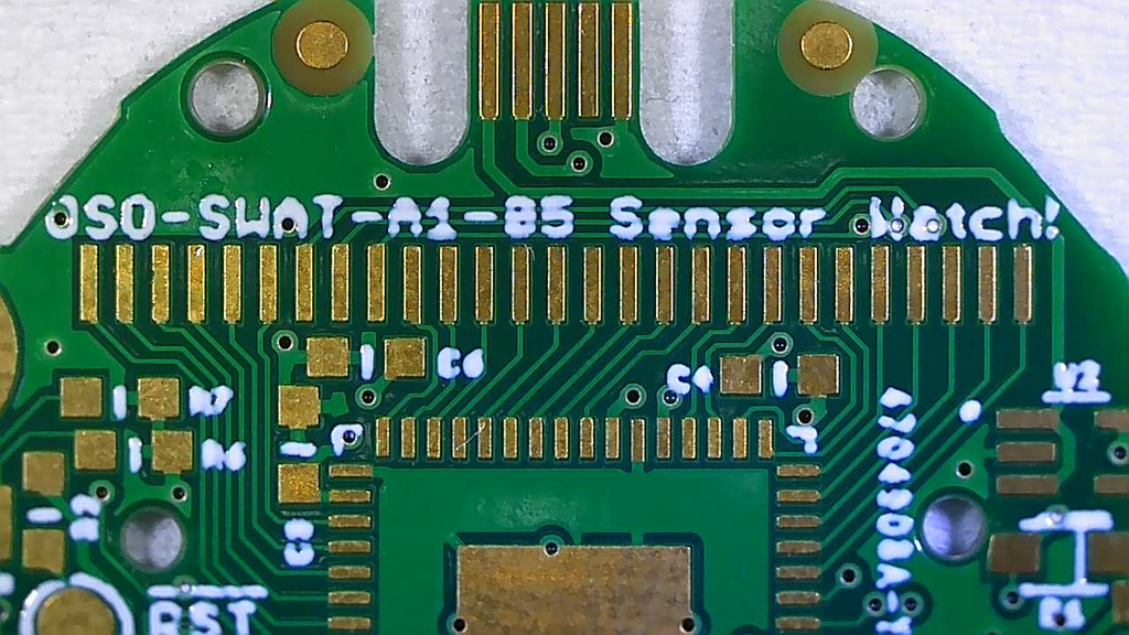 a closeup of a green sensor watch PCB